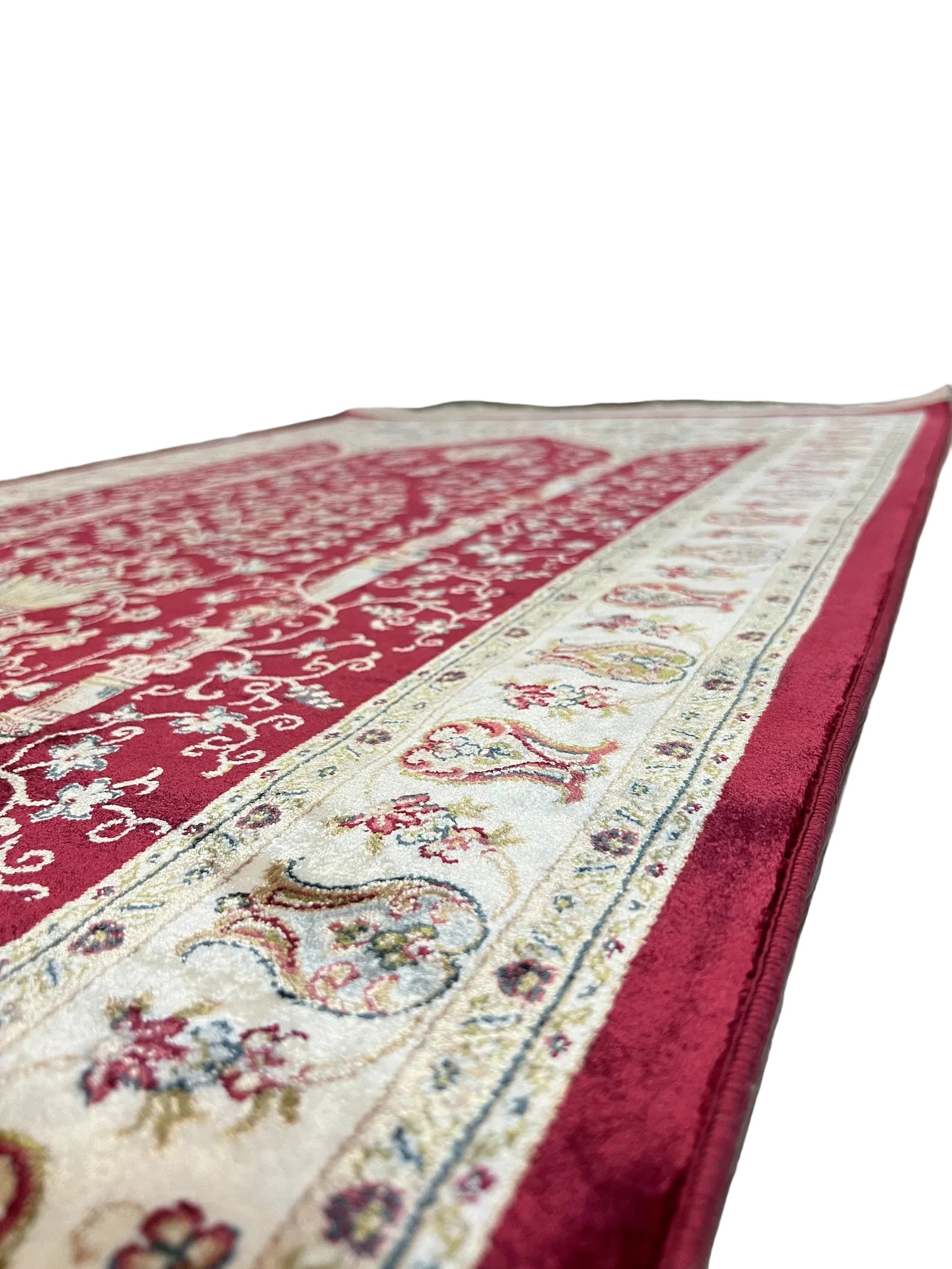 Close-up of a patterned rug with a red border on a wooden floor.
